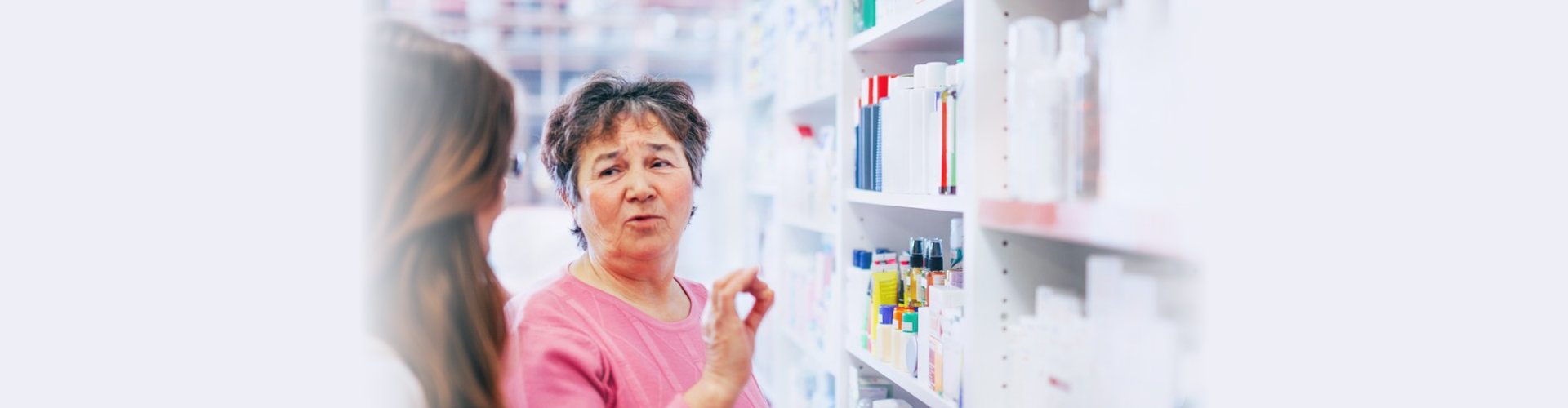 pharmacist discusses medication assortment with senior customer